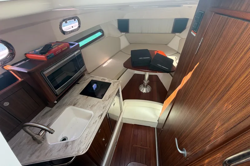 Slide: The Image of 2017 Pursuit OS 325 Offshore cabin interior with kitchenette and seating area. - 35