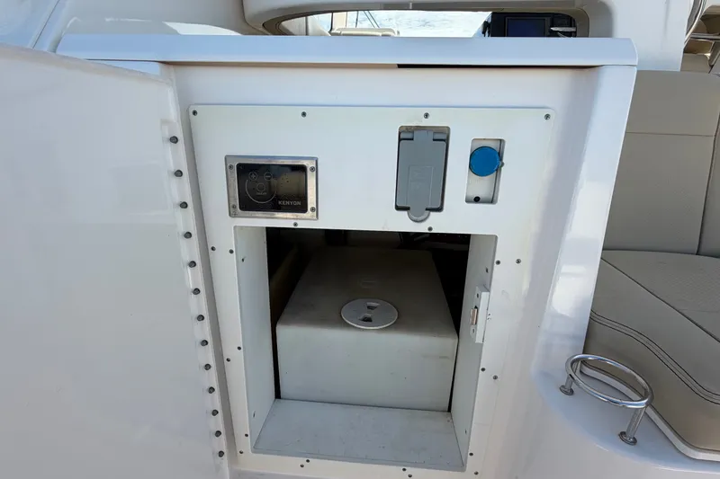 Slide: The Image of 2017 Pursuit OS 325 Offshore boat interior storage compartment with Kenyon control panel. - 19