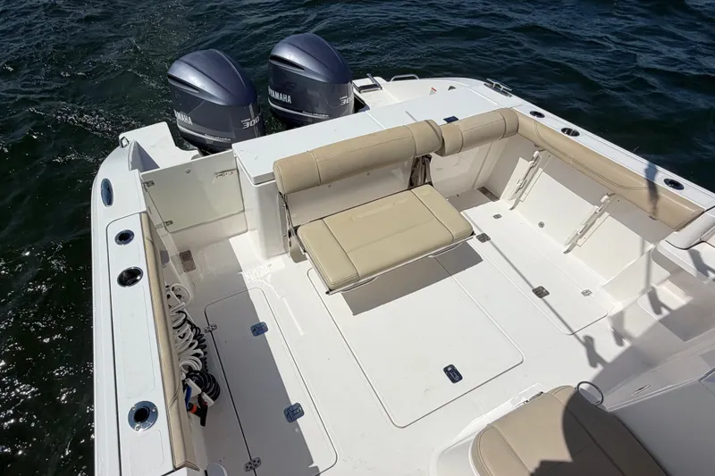 Slide: The Image of 2017 Pursuit OS 325 Offshore boat deck with Yamaha engines, beige seating, and rod holders. - 11