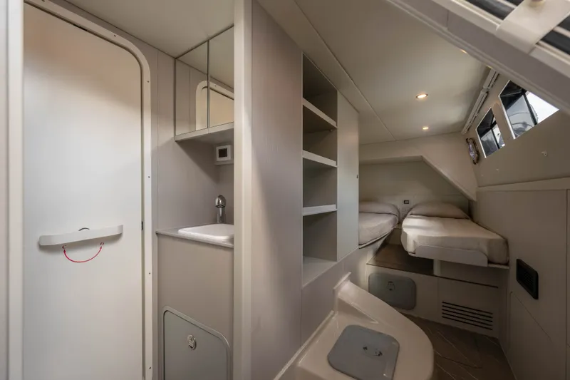 Slide: The Image of The cabin of the 2028 Absolute Navetta 58 features a modern design with twin beds and storage. - 20