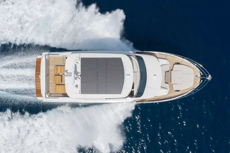 Slide: The Image of Aerial view of a luxury motor yacht speeding across blue waters. - 1