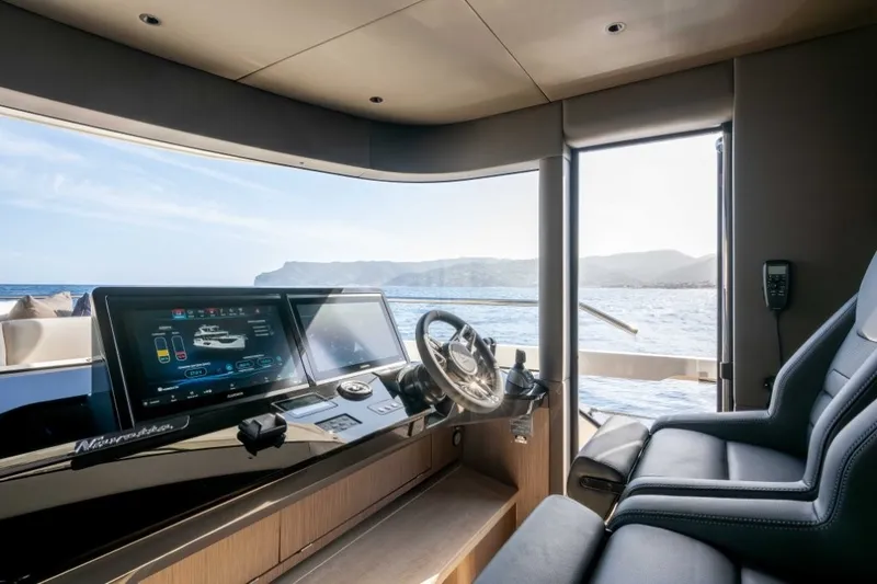 Slide: The Image of The helm of the 2028 Absolute Navetta 58 with modern instruments and a sea view. - 12