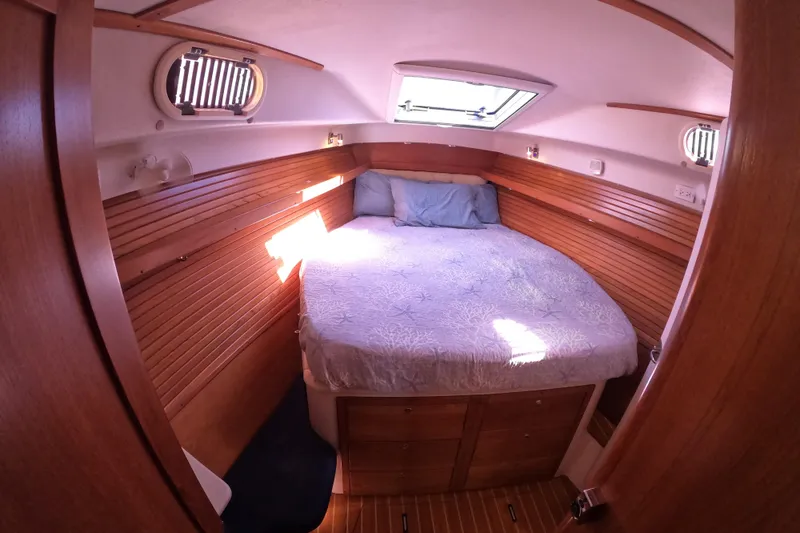 Slide: The Image of Cozy cabin interior of 2005 Catalina Morgan 440 sailboat with wooden paneling and bed. - 27