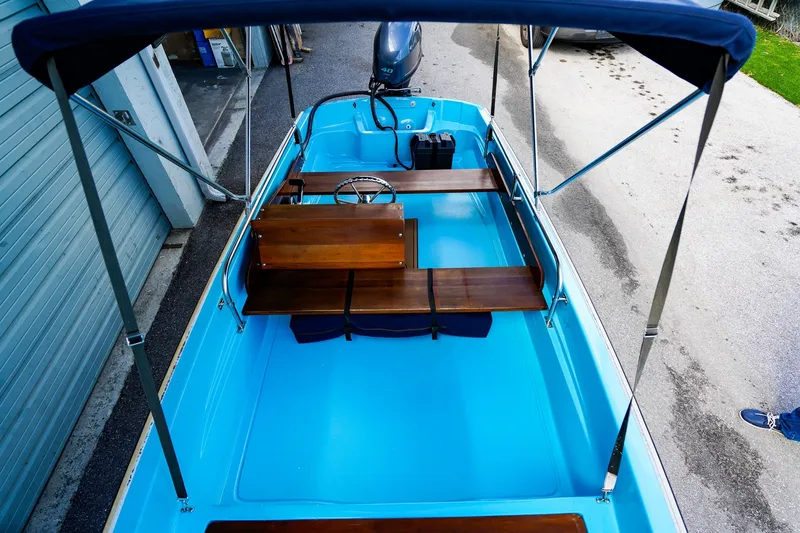 Slide: The Image of 1973 Boston Whaler 13 Sport boat with blue interior and wooden seats. - 14