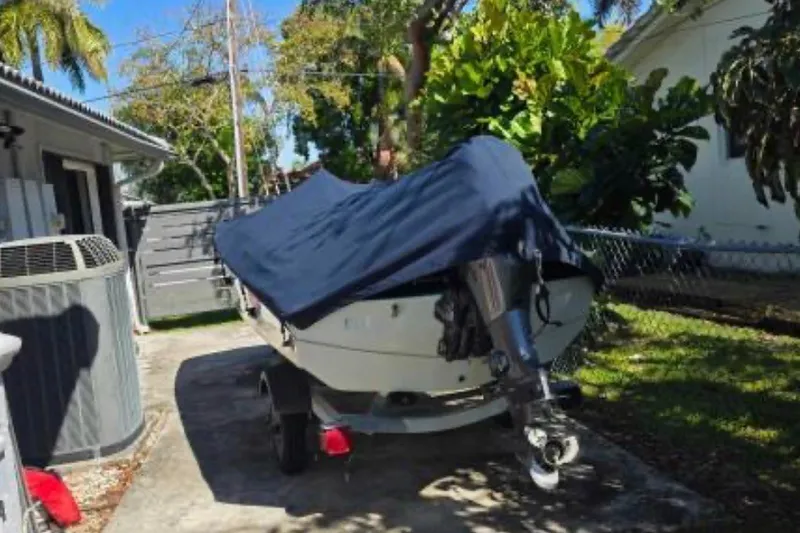 Slide: The Image of 1973 Boston Whaler 13 Sport boat covered and parked in a driveway. - 15