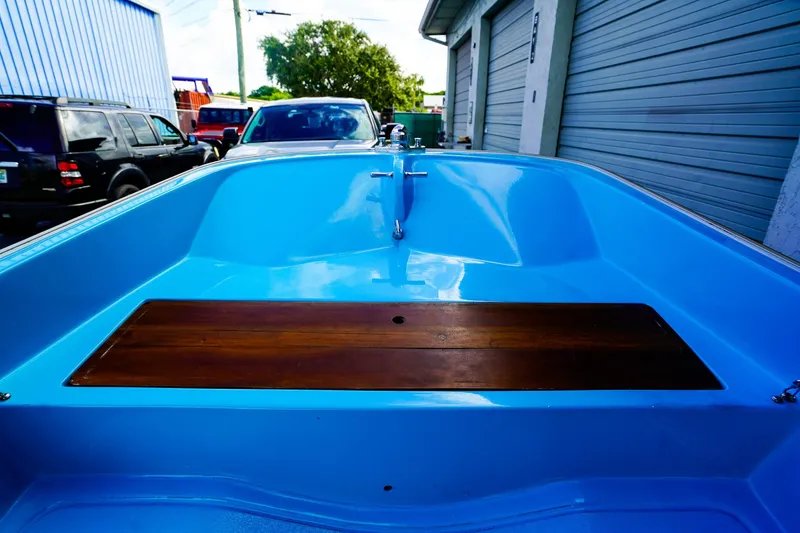 Slide: The Image of 1973 Boston Whaler 13 Sport boat interior with blue hull and wooden seat. - 11