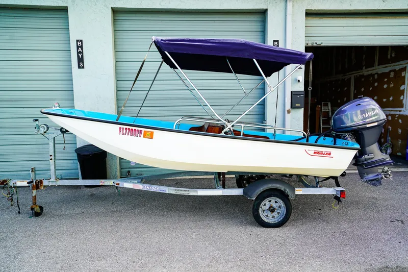 The Image of 1973 Boston Whaler 13 Sport boat on trailer with Yamaha outboard motor. - 0