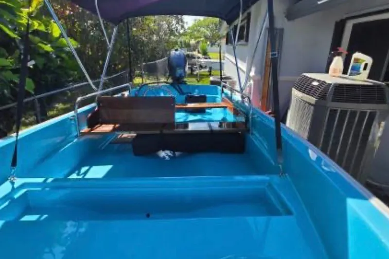 Slide: The Image of 1973 Boston Whaler 13 Sport boat with blue interior, parked outdoors. - 7