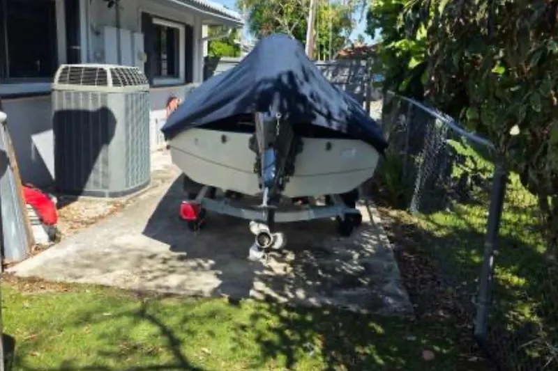 Slide: The Image of 1973 Boston Whaler 13 Sport boat covered and parked beside a house. - 16