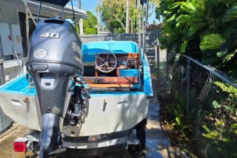 Slide: The Image of 1973 Boston Whaler 13 Sport boat with 40 HP outboard motor, parked outdoors. - 9