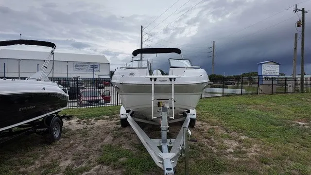 Slide: The Image of A white Stingray 22DC boat from 2027 is on a trailer on a grassy area. - 2