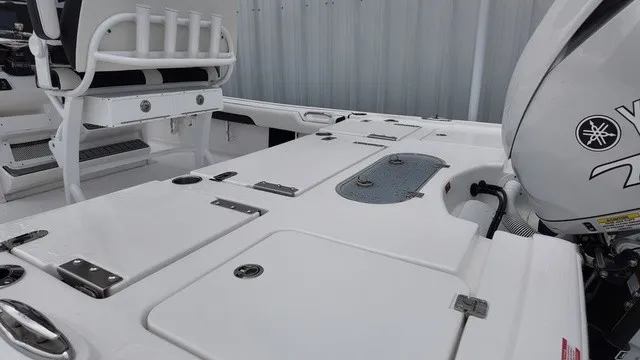 Slide: The Image of The image shows the deck of a Tidewater 2500 Carolina Bay boat with storage and engine. - 17
