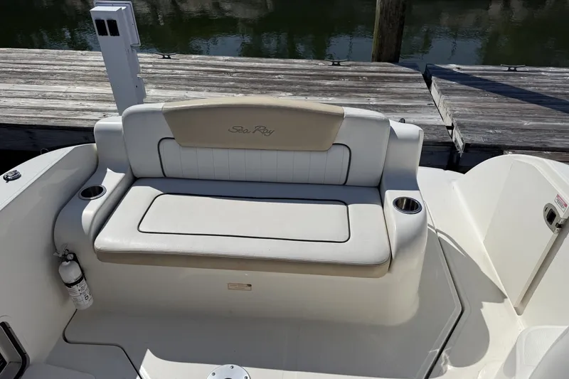 Slide: The Image of 2009 Sea Ray 230 Sundancer boat seating area with cup holders and dock view. - 7