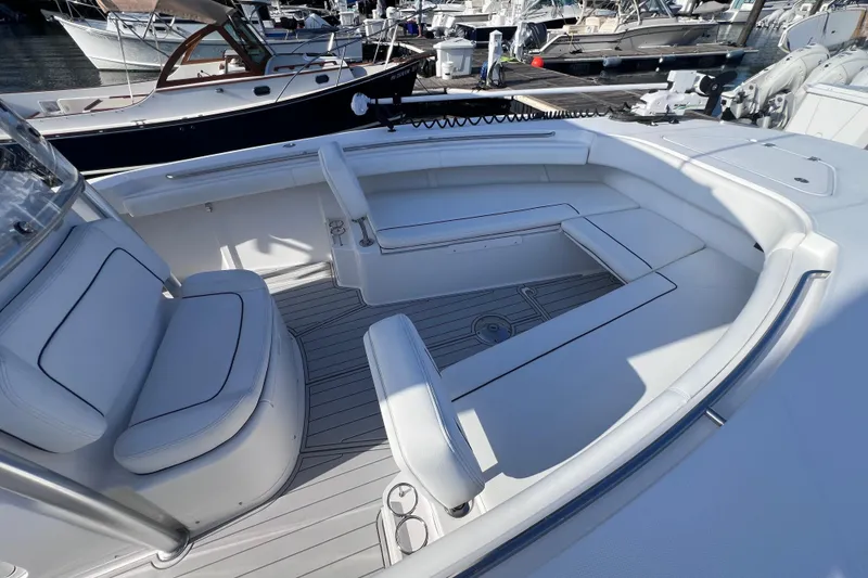 Slide: The Image of 2020 Southport 33 FE boat interior with white seating and sleek design at a marina. - 39