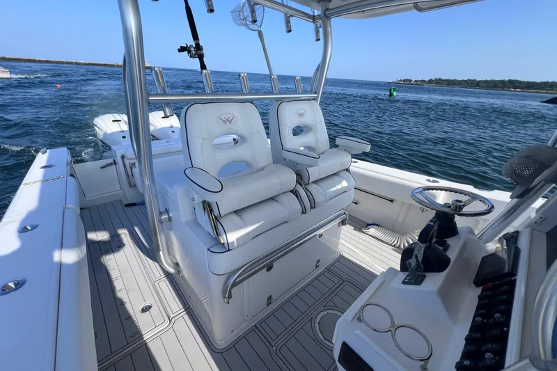Slide: The Image of 2020 Southport 33 FE boat interior with helm and seating, cruising on open water. - 25