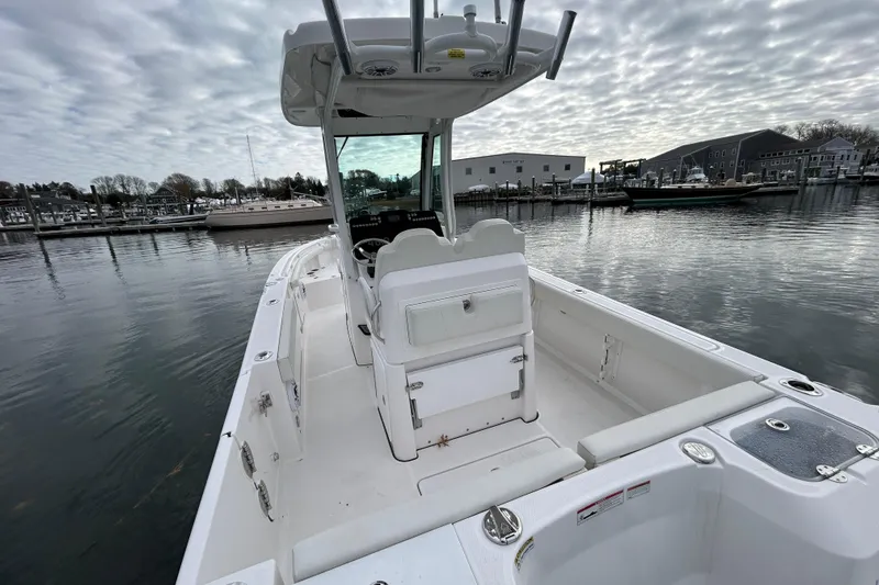 Slide: The Image of 2023 Everglades 235 Center Console boat docked in a marina under cloudy skies. - 17
