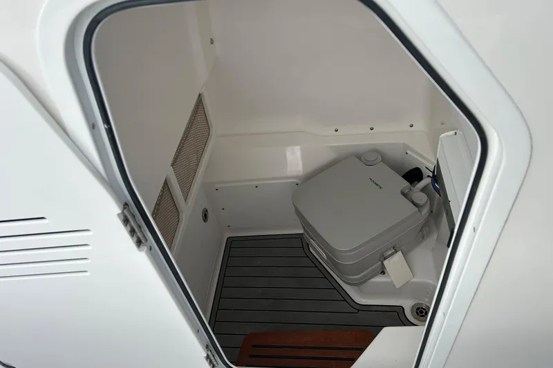 Slide: The Image of 2023 Everglades 235 Center Console boat interior with portable toilet. - 25