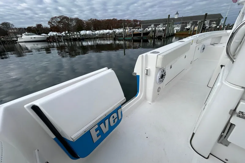 Slide: The Image of 2023 Everglades 235 Center Console boat docked at marina under cloudy sky. - 22