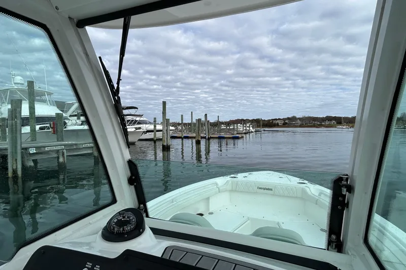Slide: The Image of 2023 Everglades 235 Center Console boat docked at a marina under cloudy skies. - 16