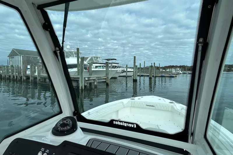 Slide: The Image of 2023 Everglades 235 Center Console boat docked at a marina under cloudy skies. - 15
