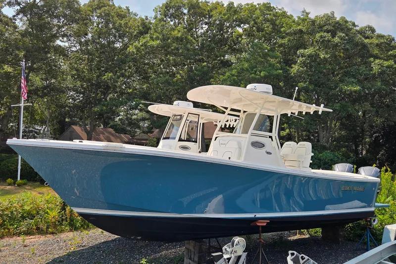 Slide: The Image of 2016 Regulator 28 Forward Seating boat displayed outdoors with lush greenery background. - 1