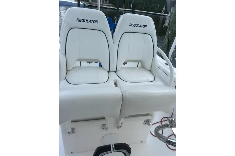 Slide: The Image of 2016 Regulator 28 Forward Seating boat with white cushioned seats. - 14