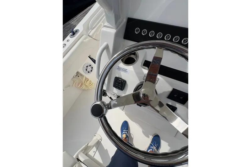 Slide: The Image of Steering wheel of a 2025 Regulator 25 boat, showcasing control panel and deck details. - 16