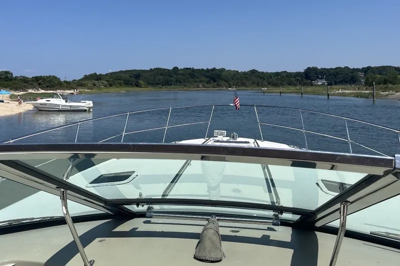 Slide: The Image of 1997 Sea Ray Sundancer 400 cruising on a serene river with scenic shoreline views. - 14