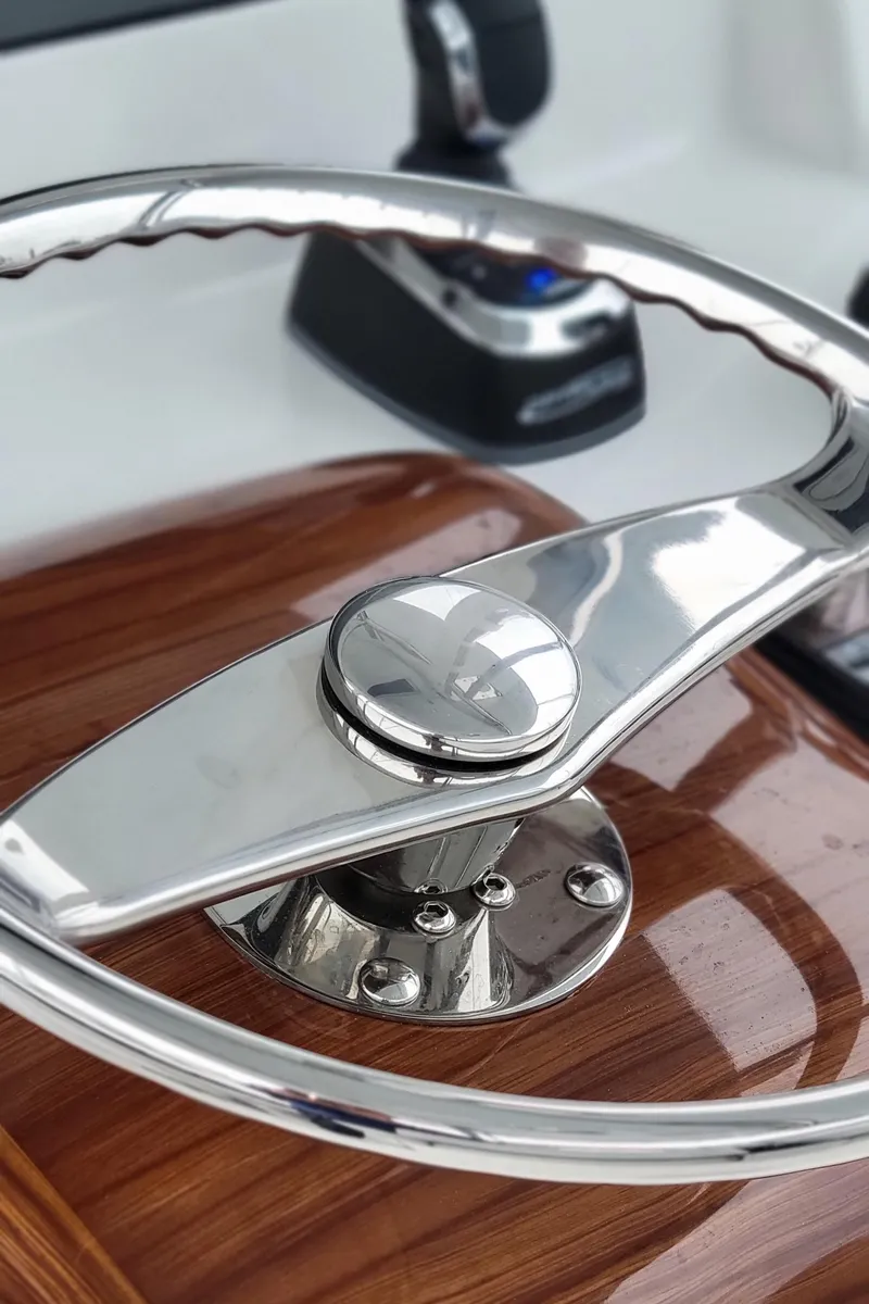 Slide: The Image of 2023 Mag Bay 33 CC steering wheel and controls, polished metal and wood finish. - 19