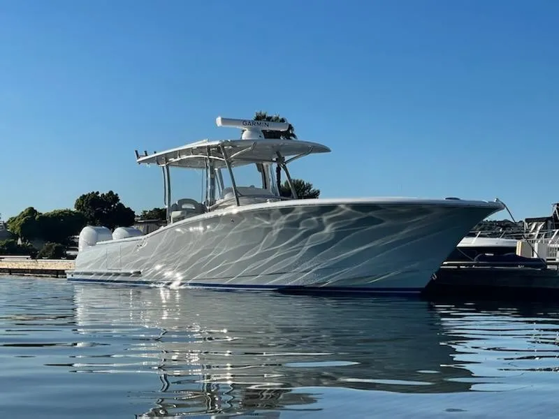Slide: The Image of 2023 Mag Bay 33 CC boat docked on calm water under clear blue sky. - 2