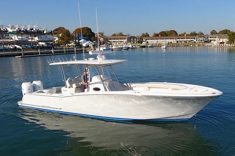 Slide: The Image of 2023 Mag Bay 33 CC boat on calm water, clear sky background. - 4