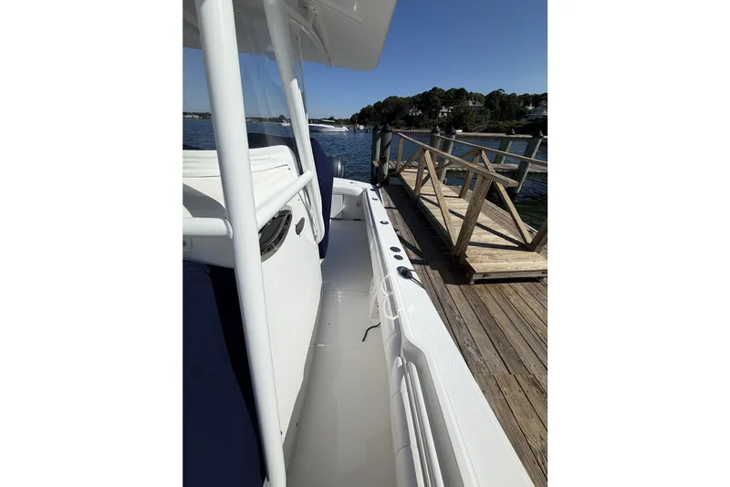 Slide: The Image of 2015 Regulator 25 boat docked by wooden pier on a sunny day. - 31