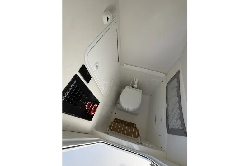 Slide: The Image of Interior of a 2015 Regulator 25 boat featuring a compact marine toilet. - 42