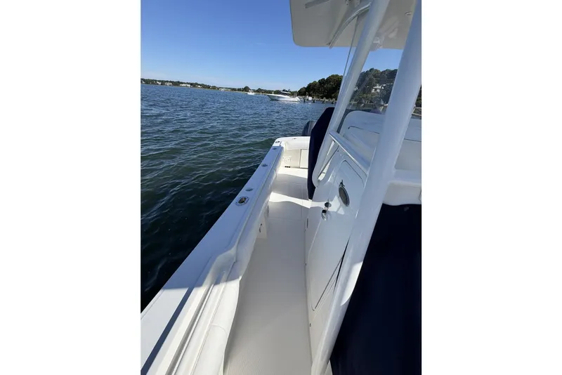 Slide: The Image of 2015 Regulator 25 boat on calm water, showcasing sleek deck design. - 32