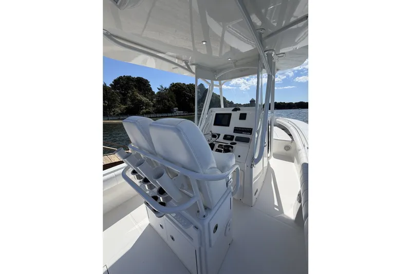 Slide: The Image of 2015 Regulator 25 boat interior with helm, seats, and control panel on a sunny day. - 29