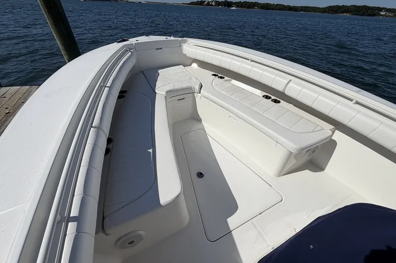 Slide: The Image of 2015 Regulator 25 boat interior with white seating, docked by the water. - 18
