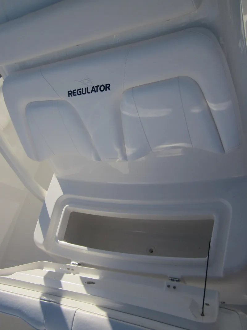 Slide: The Image of A white storage compartment lid with Regulator logo, open, revealing an empty storage space. - 24
