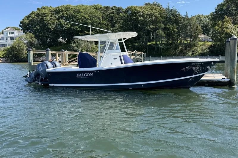 The Image of 2015 Regulator 25 boat docked on a sunny day with lush greenery in the background. - 1
