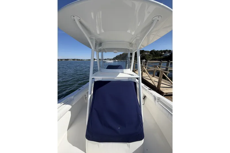 Slide: The Image of 2015 Regulator 25 boat docked by a wooden pier on a sunny day. - 26