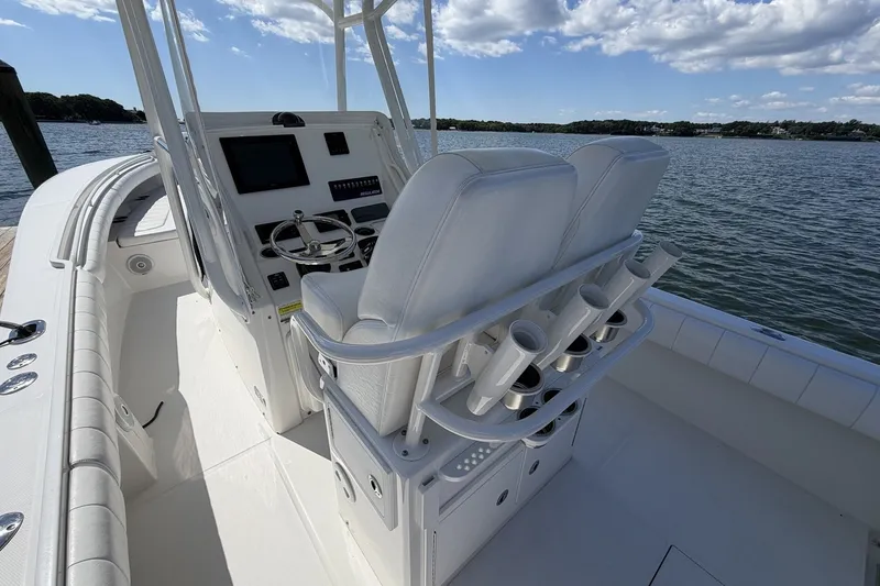 Slide: The Image of 2015 Regulator 25 boat cockpit with dual seats and steering console on a sunny day. - 30