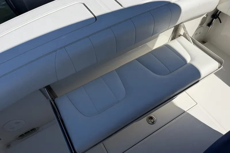 Slide: The Image of 2015 Regulator 25 boat with white cushioned seating and storage compartment. - 39