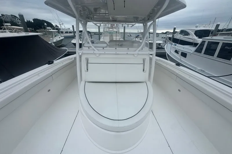 Slide: The Image of 2017 Stamas 390 Tarpon boat interior with white seating and docked boats in background. - 4