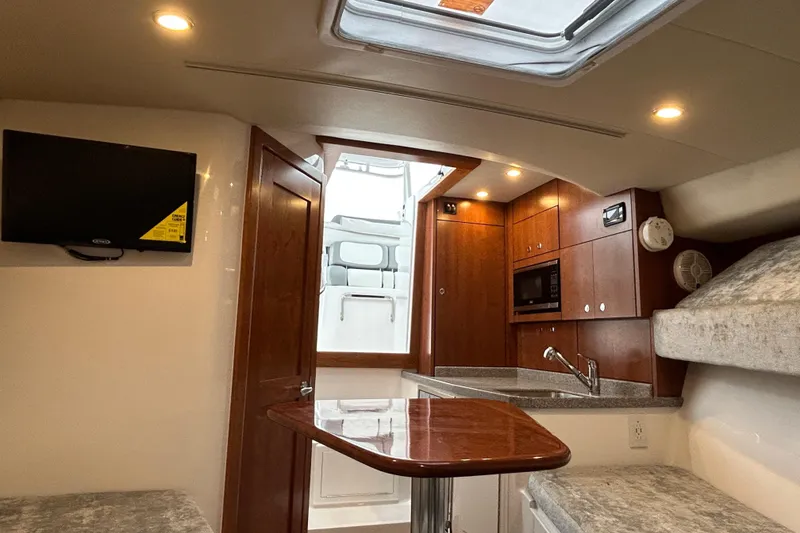 Slide: The Image of 2024 Albemarle 30 Express cabin interior with kitchenette, TV, and seating area. - 62