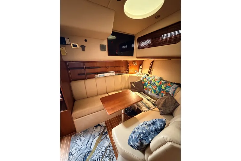 Slide: The Image of Interior of 2003 Rampage 38 Express yacht with cozy seating and wooden table. - 9