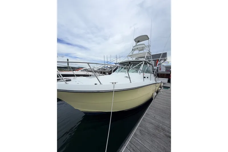 Slide: The Image of 2003 Rampage 38 Express boat docked at marina under cloudy sky. - 10