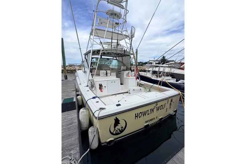 Slide: The Image of 2003 Rampage 38 Express boat docked, featuring "Howlin' Wolf" name on the stern. - 3