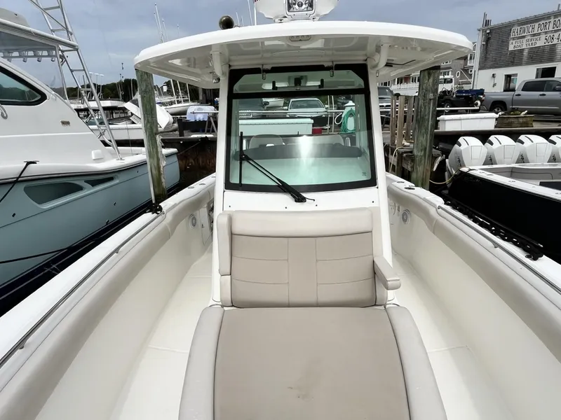 Slide: The Image of 2018 Boston Whaler 330 Outrage boat docked at marina, showcasing seating and helm. - 27