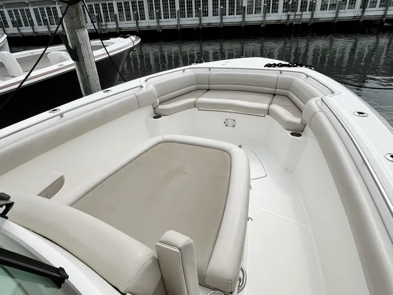 Slide: The Image of 2018 Boston Whaler 330 Outrage boat with spacious seating area at dock. - 25