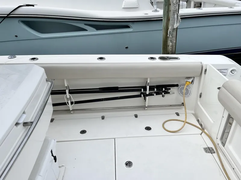 Slide: The Image of 2018 Boston Whaler 330 Outrage boat interior with fishing rod storage and seating. - 11