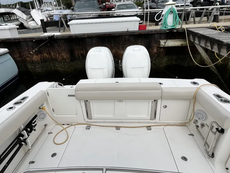 Slide: The Image of 2018 Boston Whaler 330 Outrage boat docked, featuring dual outboard engines. - 9